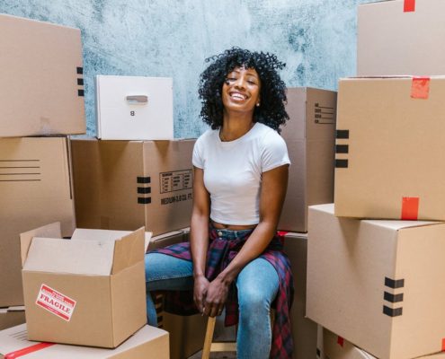 student surrounded by moving boxes